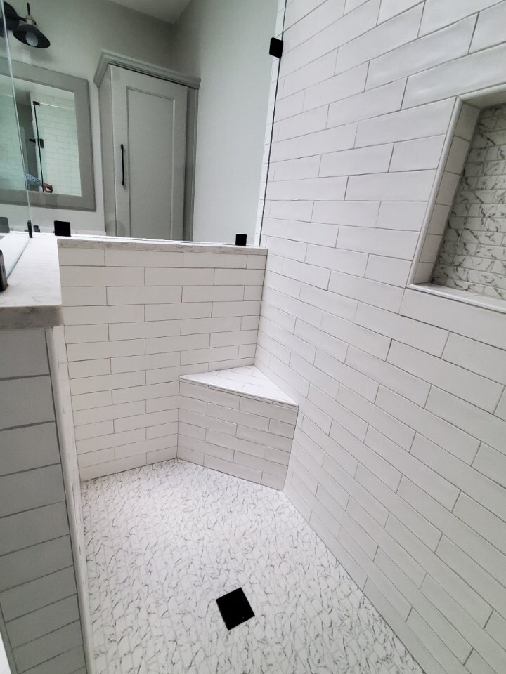 Custom walk-in shower with white subway tile and built-in bench by Grace Alon Builders in Roanoke Metropolitan