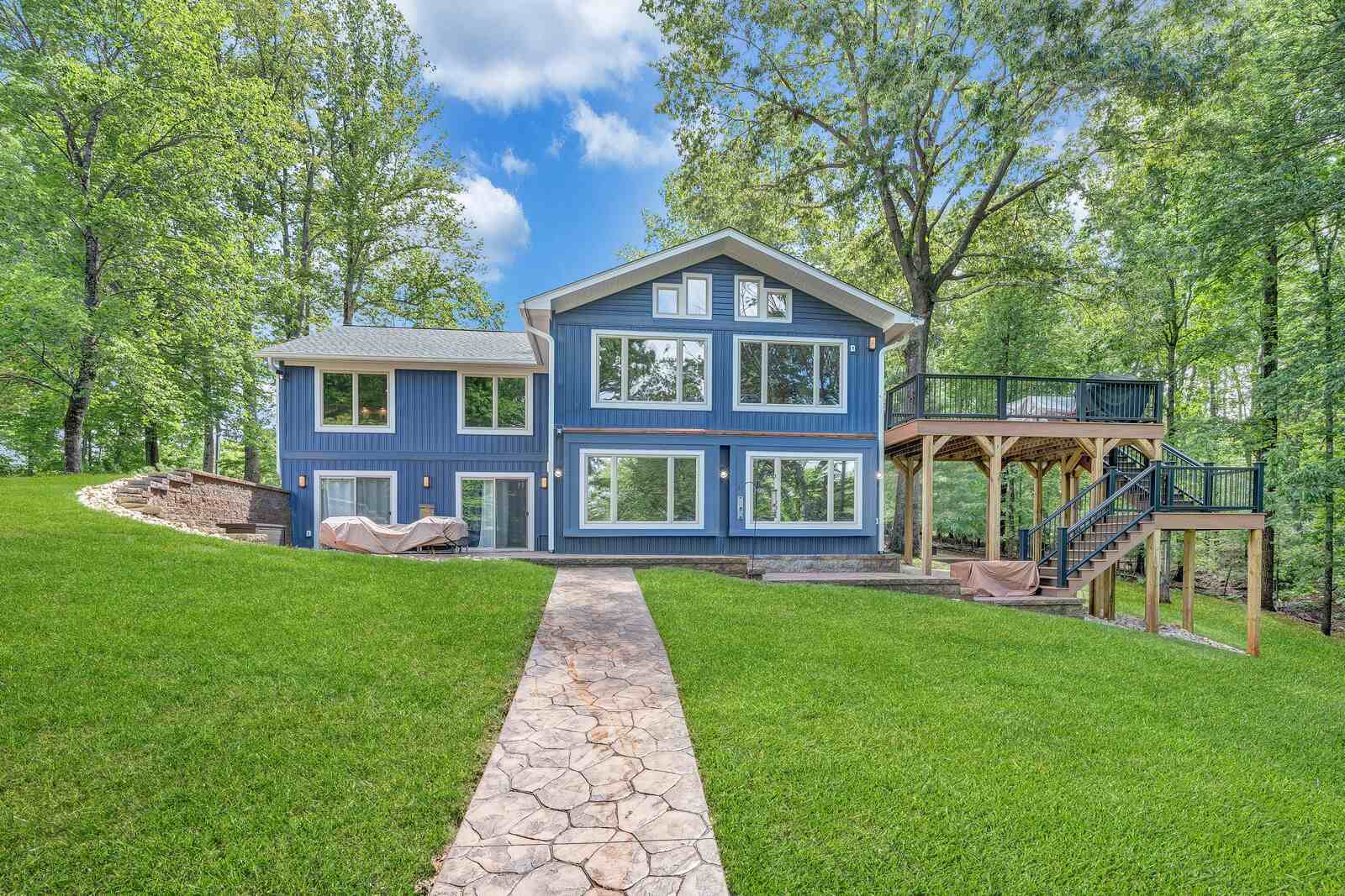 Custom lakefront home exterior by Grace Alon Builders in Smith Mountain Lake featuring large windows and elevated deck